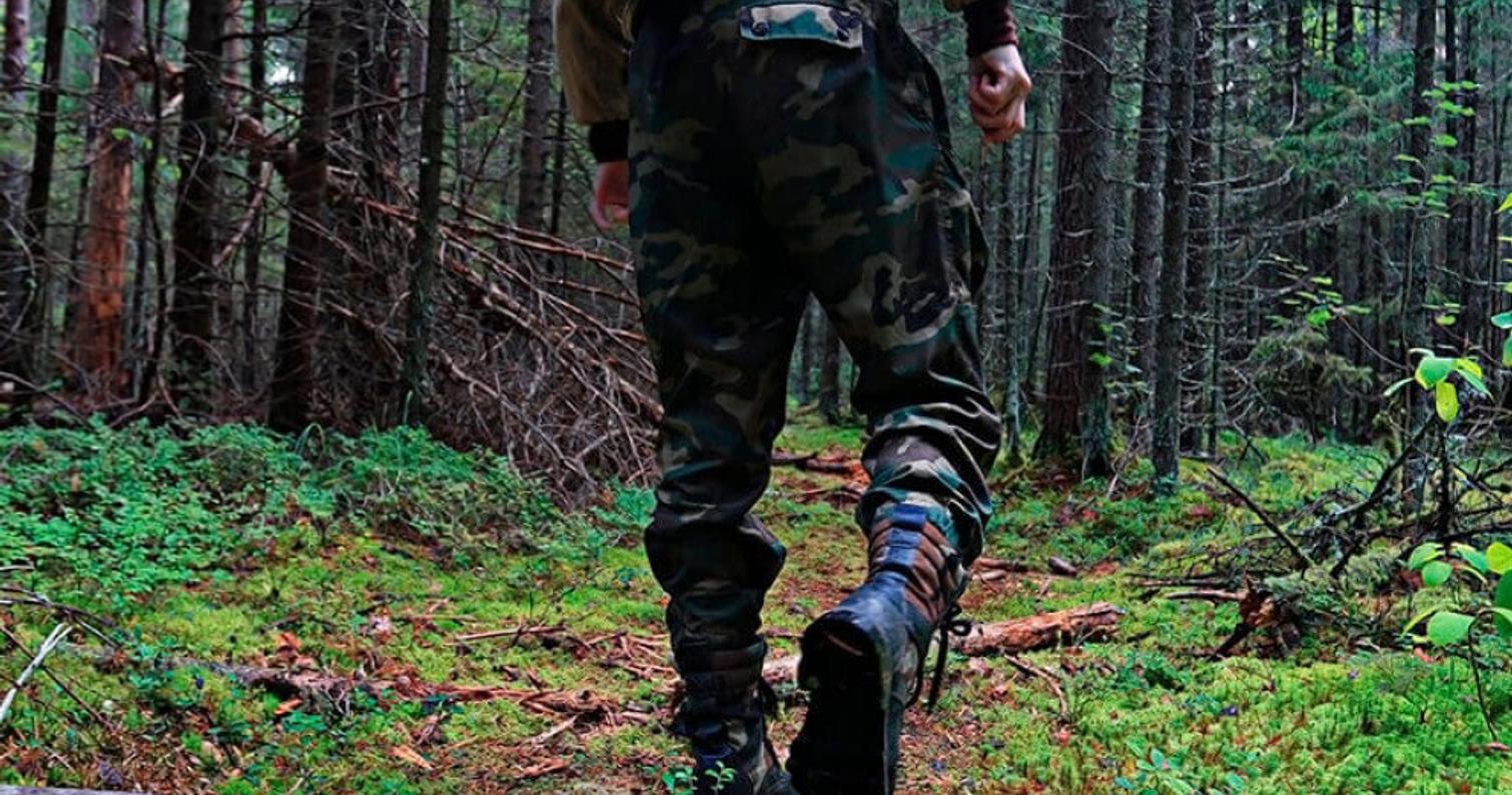 Er&auml;varusteisiin pukeutunut henkil&ouml; k&auml;velee mets&auml;ss&auml;.