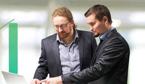 Kaksi atFlow'n digiasiantuntijaa keskustelee tietokoneen &auml;&auml;rell&auml;.